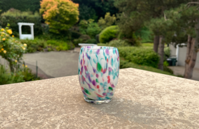 Candle votive pink, green, blue on white background